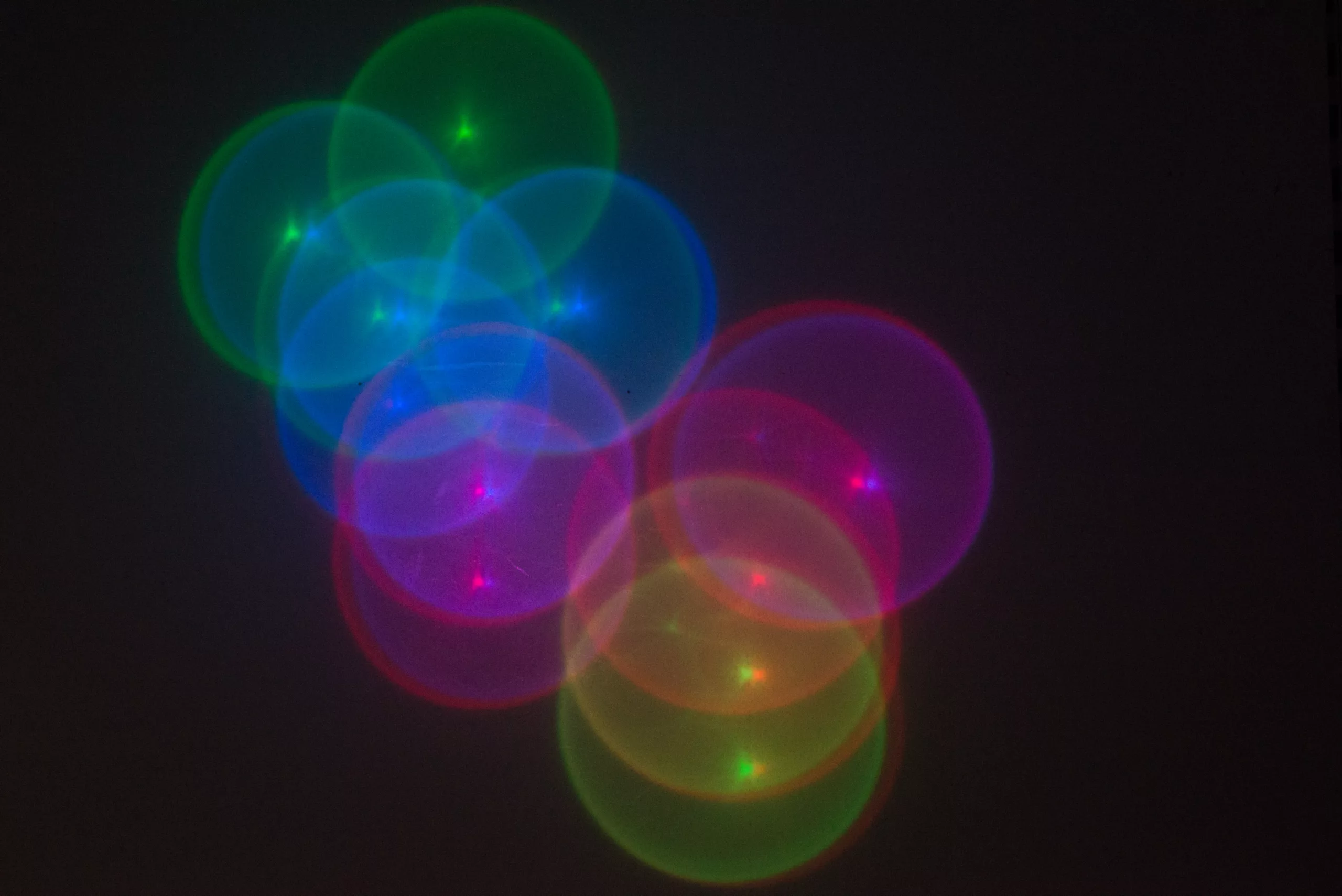 Multicolored, overlapping circles are projected onto a dark background.